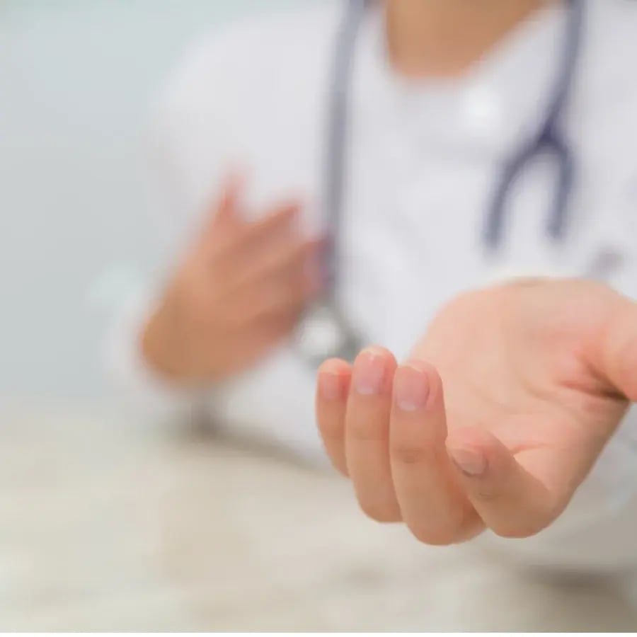 Un médecin tend la main à un patient, offrant de l'aide et du soutien dans un cadre médical.